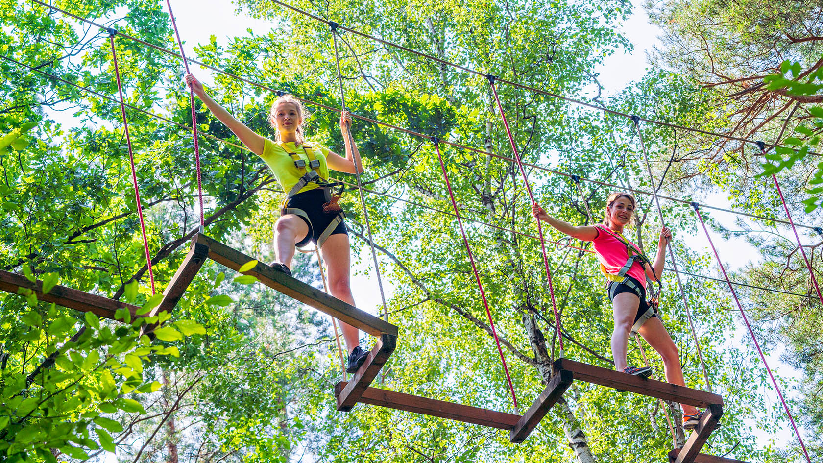 Dwie osoby pokonujące wiszącą przeszkodę