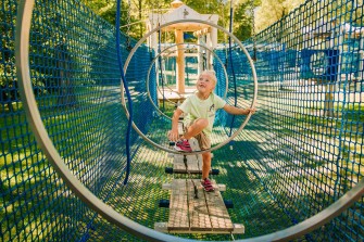 Dziecko pokonujące przeszkody w parku linowym